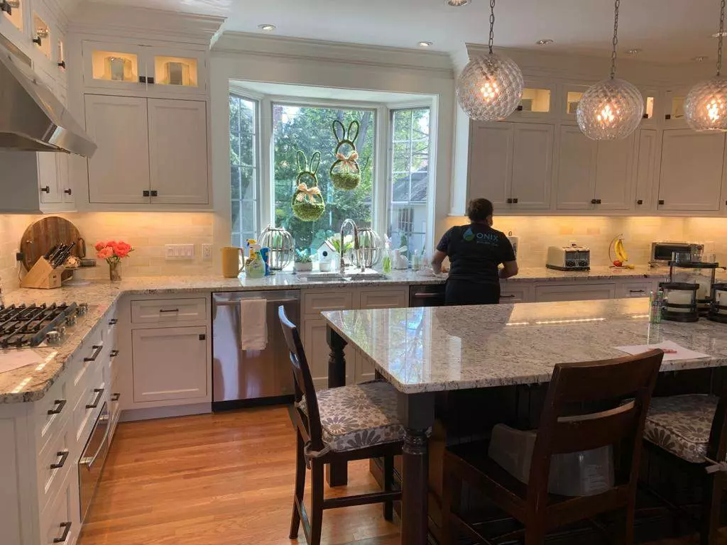 A kitchen with white cabinets and a center island in Boston.