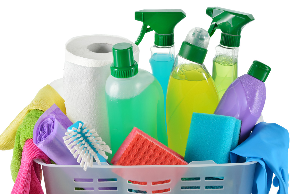 an image of a white background with a basket overflowing with assorted cleaning products