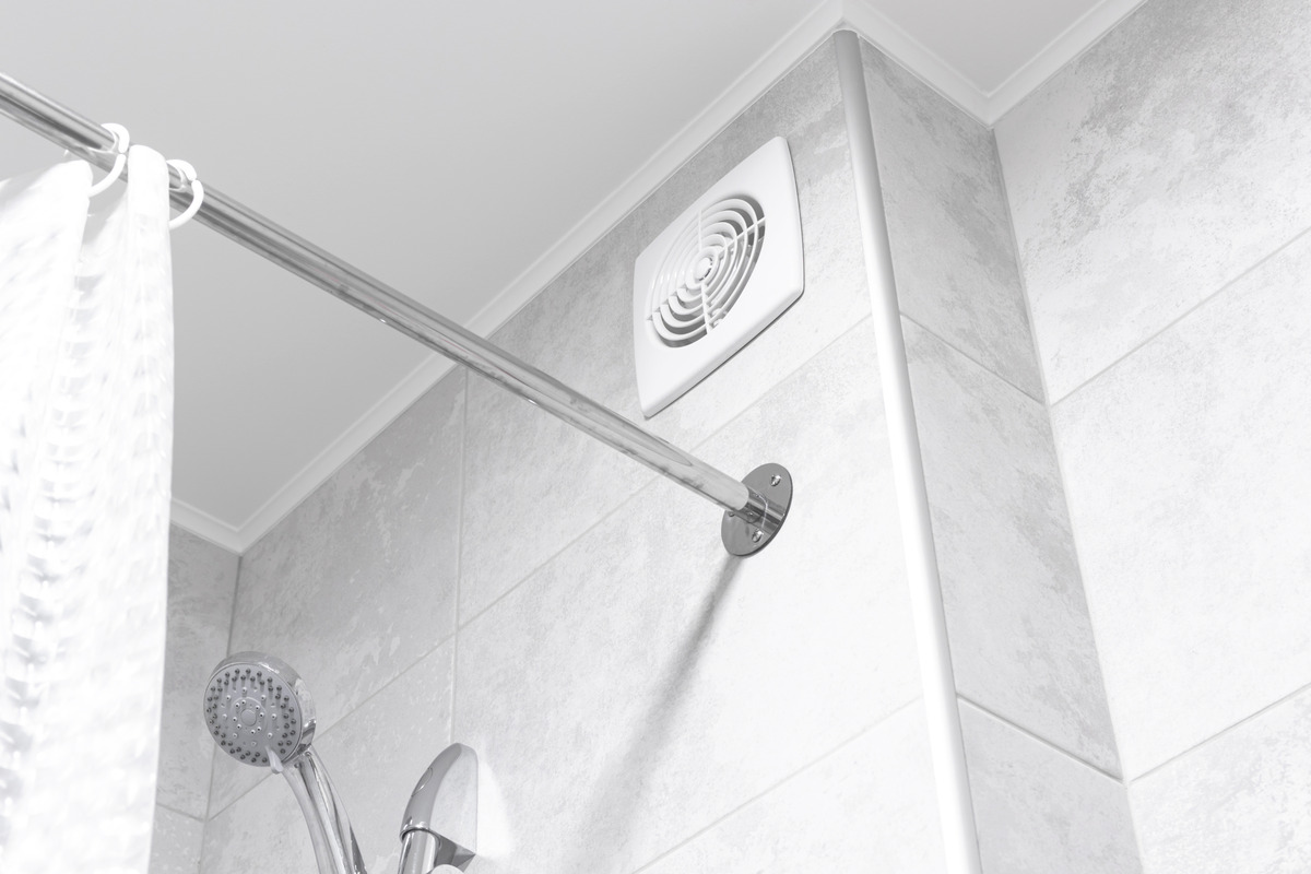 an image of a bathroom featuring a wall-mounted ventilation fan positioned above the shower