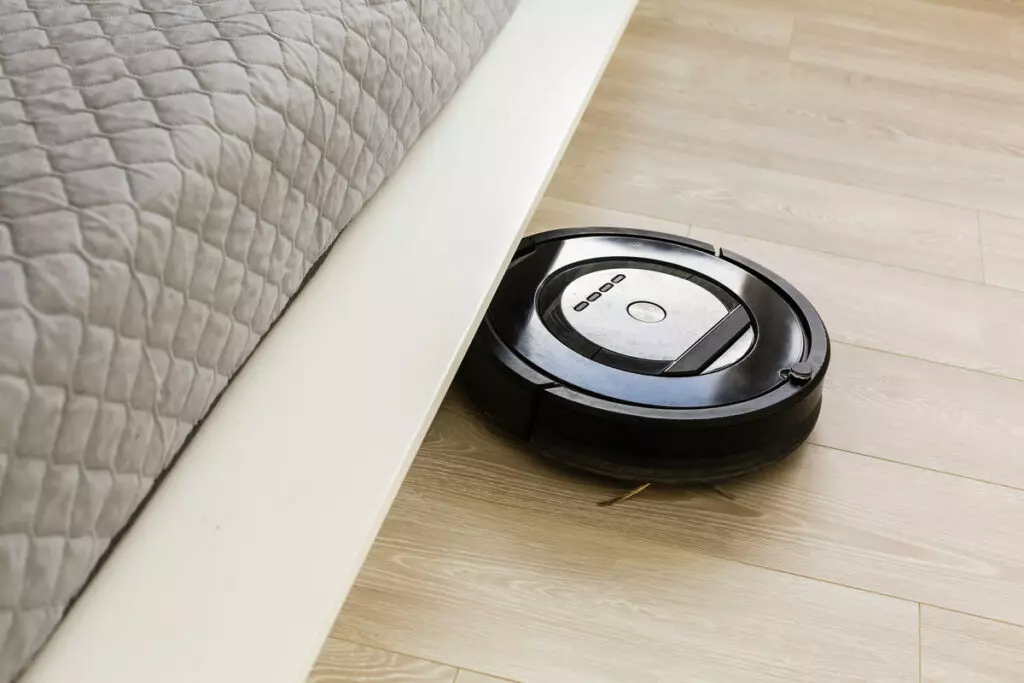 an image of a robot vacuum approaching the space beneath a bed