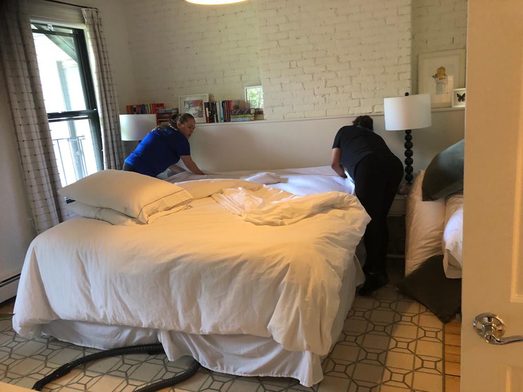 an image of two female onix cleaners assisting each other in cleaning the mattress