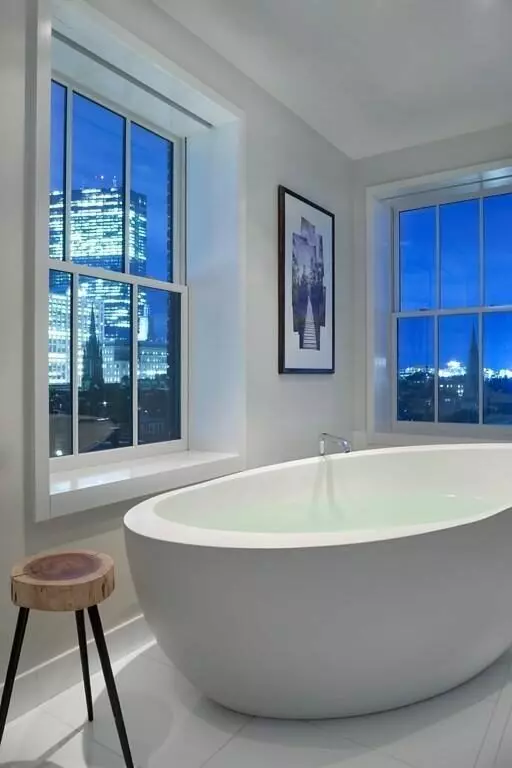 A luxurious bathroom with a large tub and a view of the city.