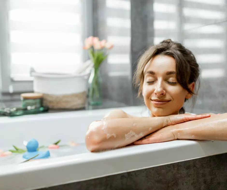 A woman is taking a relaxing bath in a bathtub.