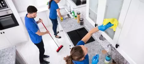 A group of people performing a deep kitchen cleaning.