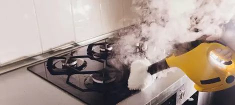 A person utilizing sanitization templates for cleaning a stove.