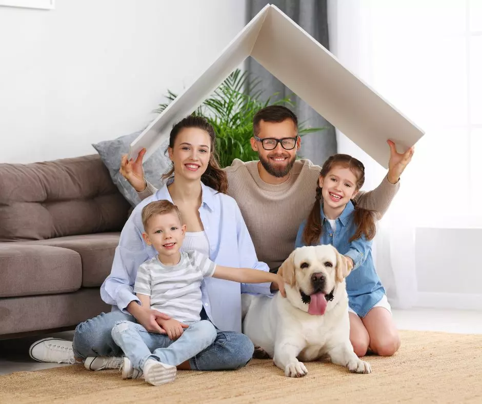 A family with a dog sitting on the floor with a house in front of them, showcasing standard cleaning standards.